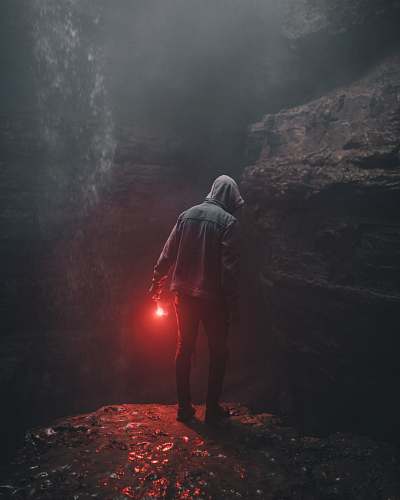united states man wearing hoodie holding red light in right hand man